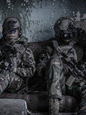 Two men sitting with gear in combat