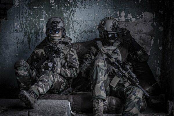 Two men sitting with gear in combat